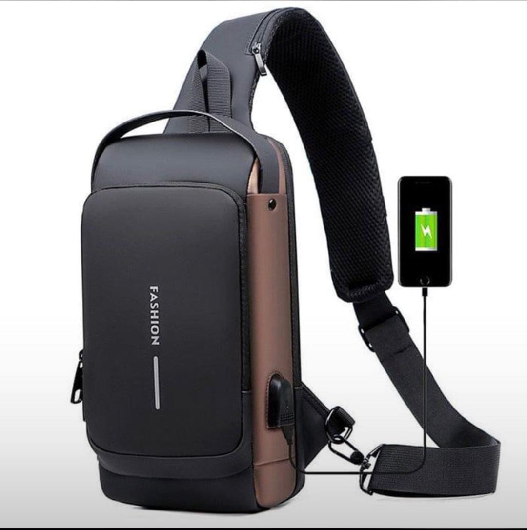 Black and brown crossbody bag with USB port and smartphone charging cable on a white background