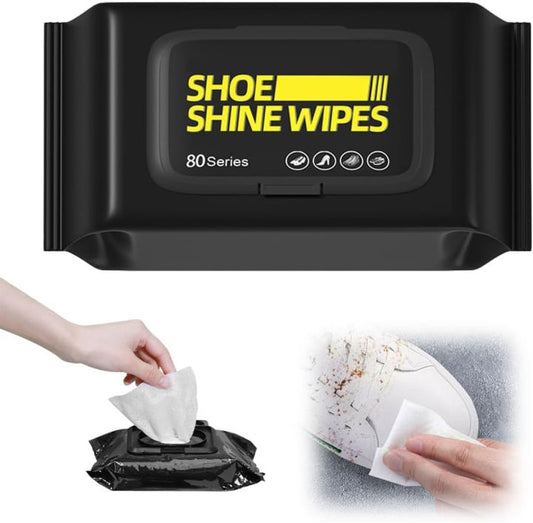 Black container of shoe shine wipes with a hand pulling out a wipe and using it on a shoe.