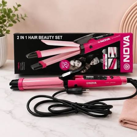 Pink and black NOVA 2-in-1 hair beauty set with a curling iron and its retail box on a light marble surface, styled with a small plant and folded towel.