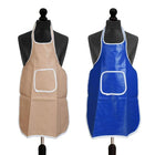 Two aprons displayed on black dress forms against a white background, one in beige and one in blue. Both aprons have a glossy finish and a white-trimmed square chest pocket.