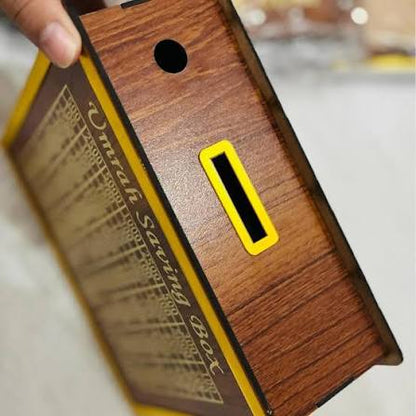 Wooden savings box with yellow label held by a hand on a blurred background